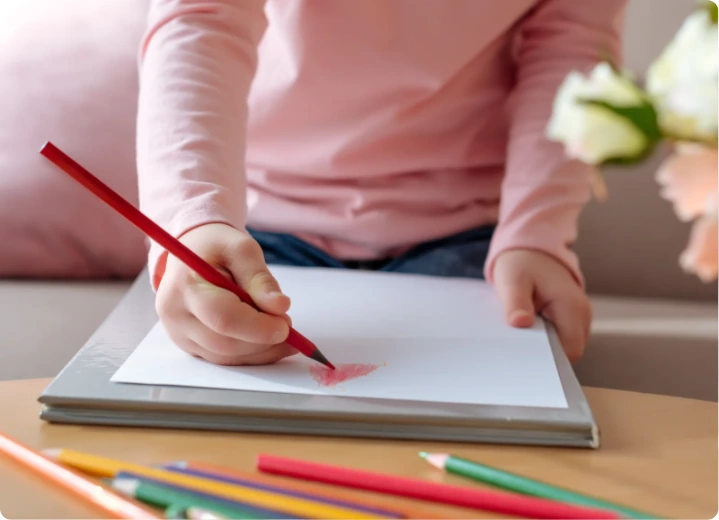 Child coloring with pencil